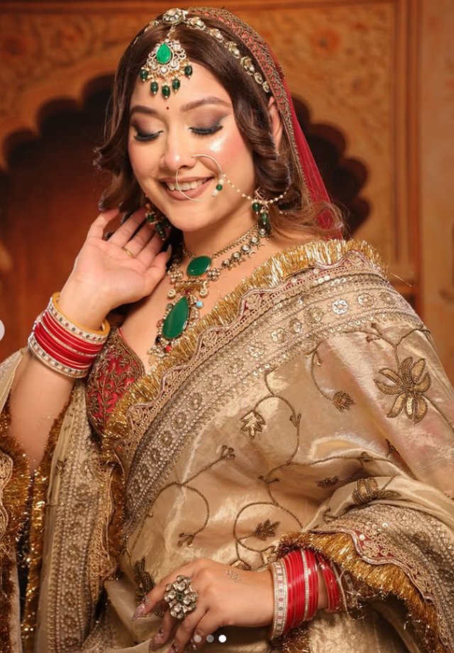 Traditional gold bridal makeup look with emerald jewellery for a wedding ceremony